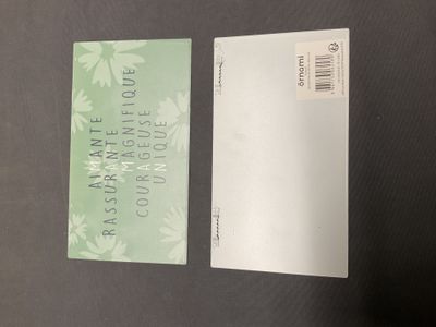 deux cartes de visite vertes et blanches posées sur une table noire