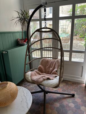 une chaise suspendue dans un coin de la pièce, à côté d'une table