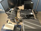 a lot of computer equipment on the table in the room