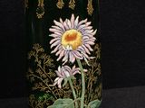 a green vase with a flower painted on it