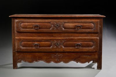 une commode ancienne avec des tiroirs en bois sculpté et des tiroirs
