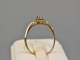 a close up of a gold ring with a diamond on top