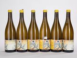six bouteilles de vin sont alignées sur une surface blanche