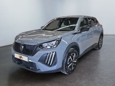 a grey car is parked in a large room with a white wall