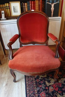 une chaise rouge posée devant une bibliothèque