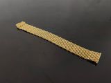 a close up of a gold bracelet on a black surface