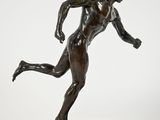 une image représentant une statue en bronze d'un homme en train de courir, posée sur un socle en marbre