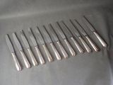 six silverplated knives are lined up in a row on a table