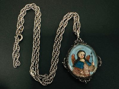 une image représentant un collier orné d'une photo d'une femme tenant un chat