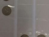 four different coins in a clear plastic bag on a table