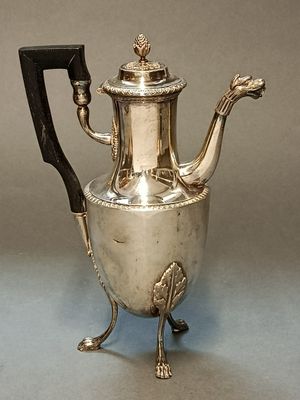 une théière ancienne en argent, dotée d'une poignée noire et d'une poignée noire