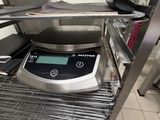 a digital scale sitting on a shelf in a kitchen
