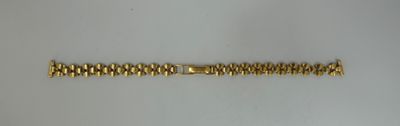 a close up of a gold bracelet on a white surface