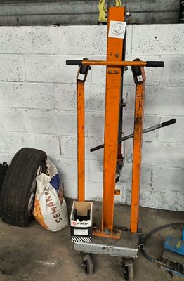 a fork lift with a tire on it in a garage