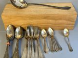 beaucoup de cuillères en argent et de cuillères à soupe sur une table