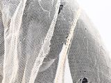 the bride is wearing a white veil with black flowers on it
