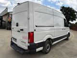 a white van parked in a lot with a tractor in the background