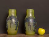 two vases sitting on a table with an apple next to them