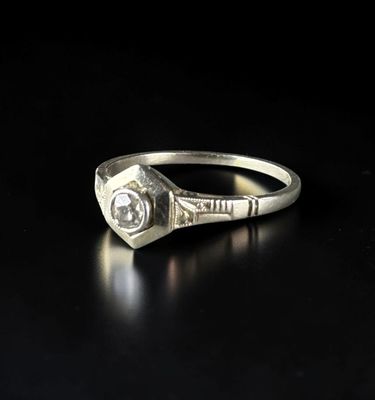 a close up of a diamond ring on a black surface