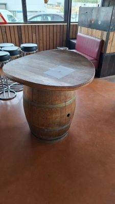 a table made out of a wine barrel on the floor