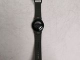 the watch is sitting on a white surface with a black strap