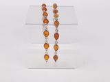a close up of a pair of earrings on a clear stand
