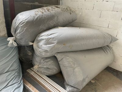 une pile de sacs de sable posée à côté d'un lit