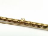 gold tone metal tie bar with a pearl in the center