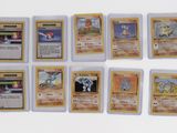 several pokemon cards are lined up on a white surface