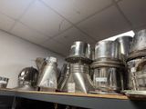 a lot of silver pots and pans on a shelf