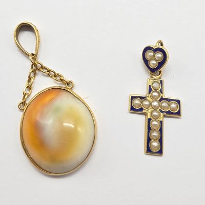 deux bijoux, dont une croix, un coquillage et un pendentif en forme de coquillage