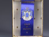 a small blue box with a blue ribbon and a small white box with a blue ribbon on it