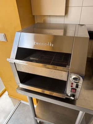 a silver oven sitting on a stand in a kitchen