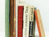plusieurs livres sont empilés sur une surface blanche
