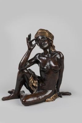 statue en bronze représentant une femme assise par terre, la main sur le visage