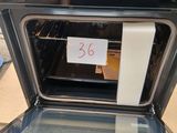 un four noir sur lequel est apposée une étiquette de prix