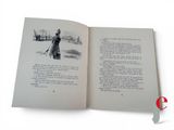 an open book with a picture of a woman walking in the snow