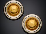 pair of gold and silver cufflinks on a black surface