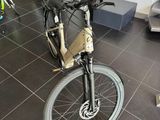un vélo posé dans une pièce où des gens sont debout tout autour