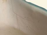 a close up of a white vase with a blue edge