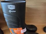 une paire de bottes en caoutchouc noires posée sur une étagère dans un magasin