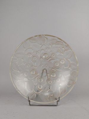 une assiette blanche ornée d'un motif, posée sur un socle