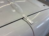 a measuring tape on the hood of a white car