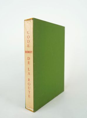 un livre vert posé sur une table blanche