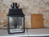 une petite lanterne noire posée sur une table à côté d'un panneau