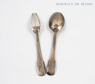 deux cuillères et une fourchette en argent sur une surface blanche
