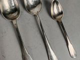 five spoons and two spoons sitting on a table
