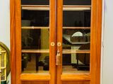 a large wooden cabinet with glass doors in a room