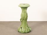a green vase that is sitting on the floor