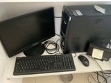 un ordinateur de bureau posé sur une table à côté d'un clavier et d'une souris